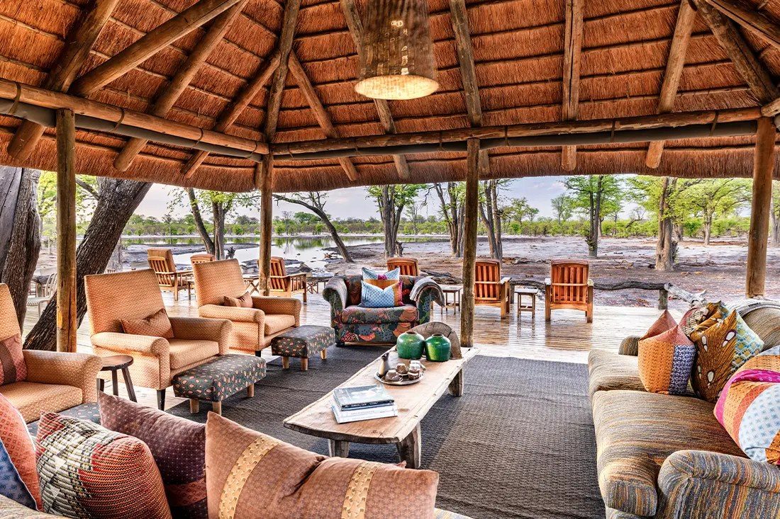 Patterned sofas and armchairs in the open thatched lounge at Elephant Pan, facing the pan