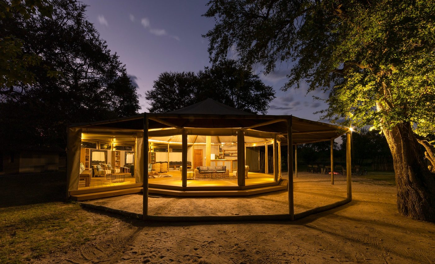 Khwai Guest House's canvas-roofed lounge lit at night, in Khwai village by Moremi's North Gate