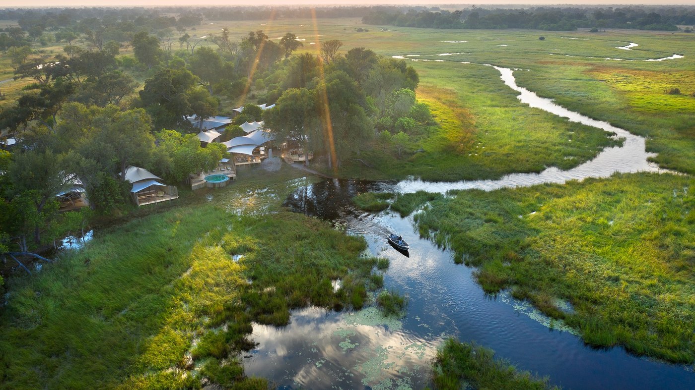 Thatched suites and pool deck on a bend of the Khwai River at Khwai Leadwood, Moremi