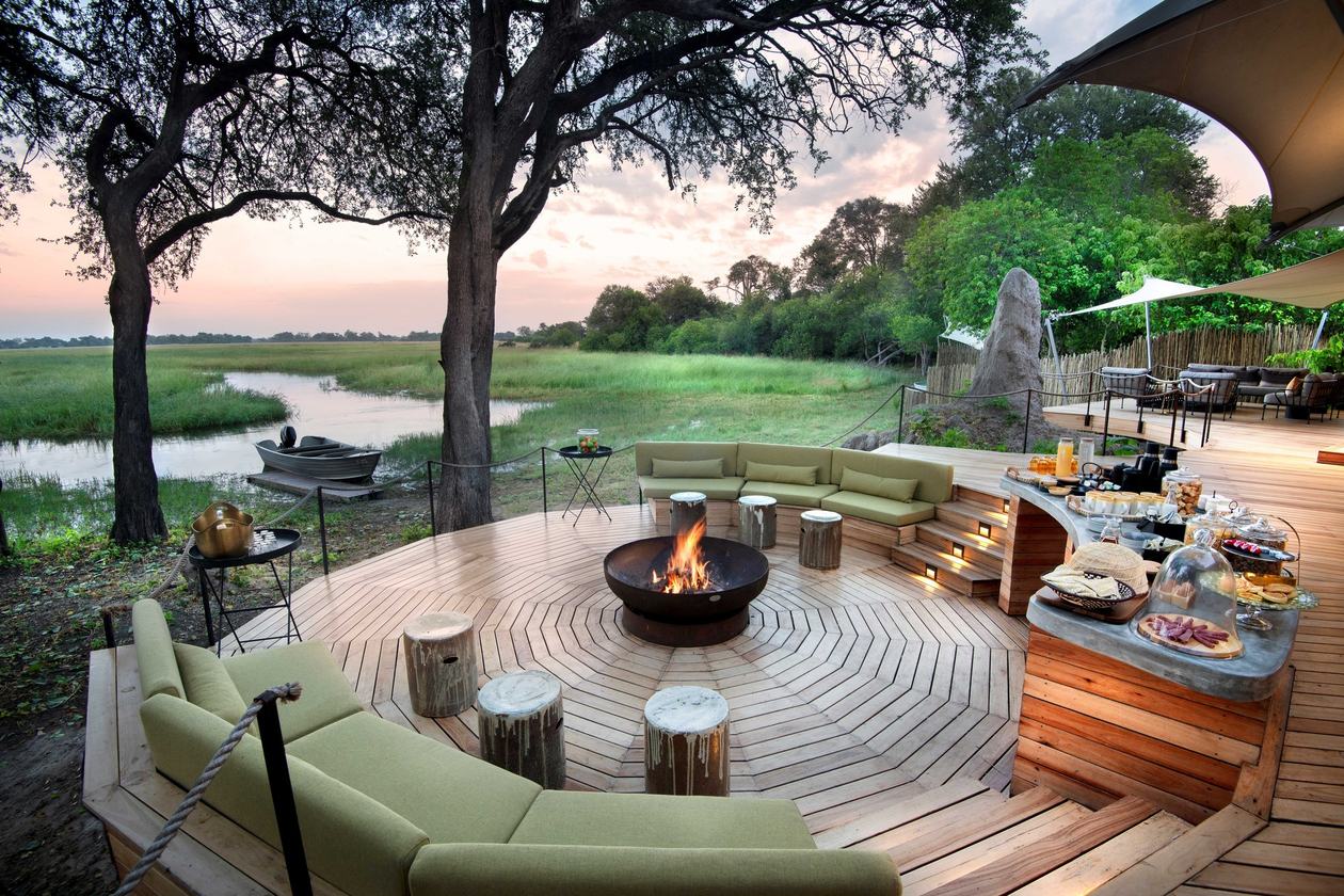 Fire-pit lounge and breakfast spread overlooking the river at Khwai Leadwood
