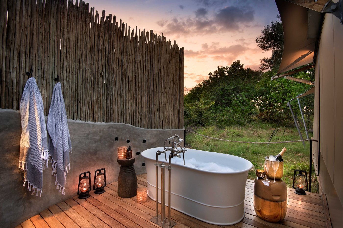 An outdoor bathtub on the suite deck at dusk at Khwai Leadwood