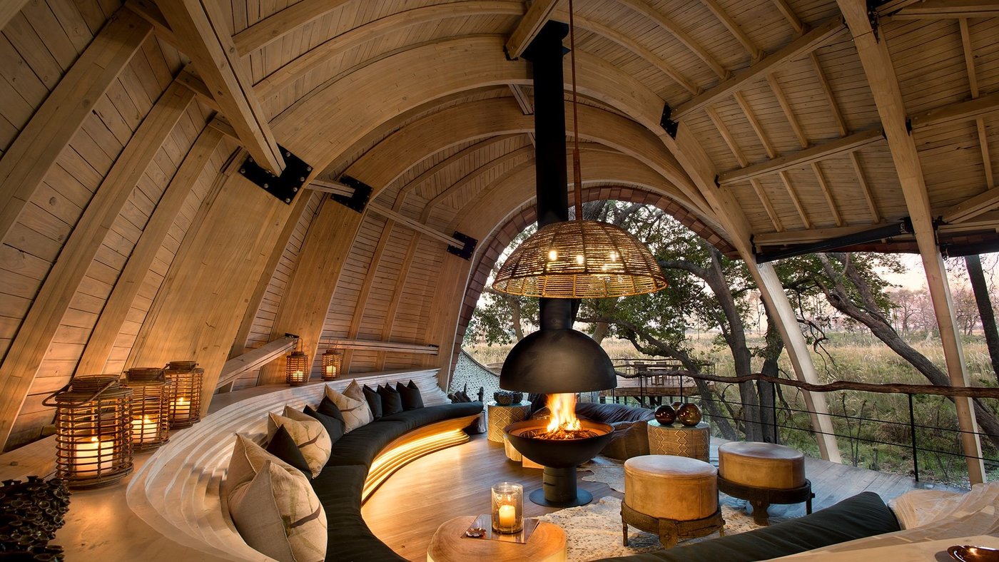 Hanging fireplace in the curved timber lounge of &Beyond Sandibe Okavango Safari Lodge near Moremi