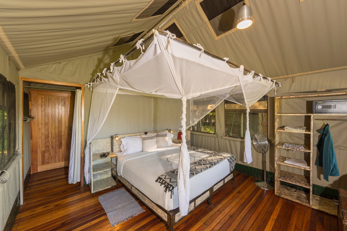Four-poster bed under mosquito netting inside a tent at Sango Safari Camp