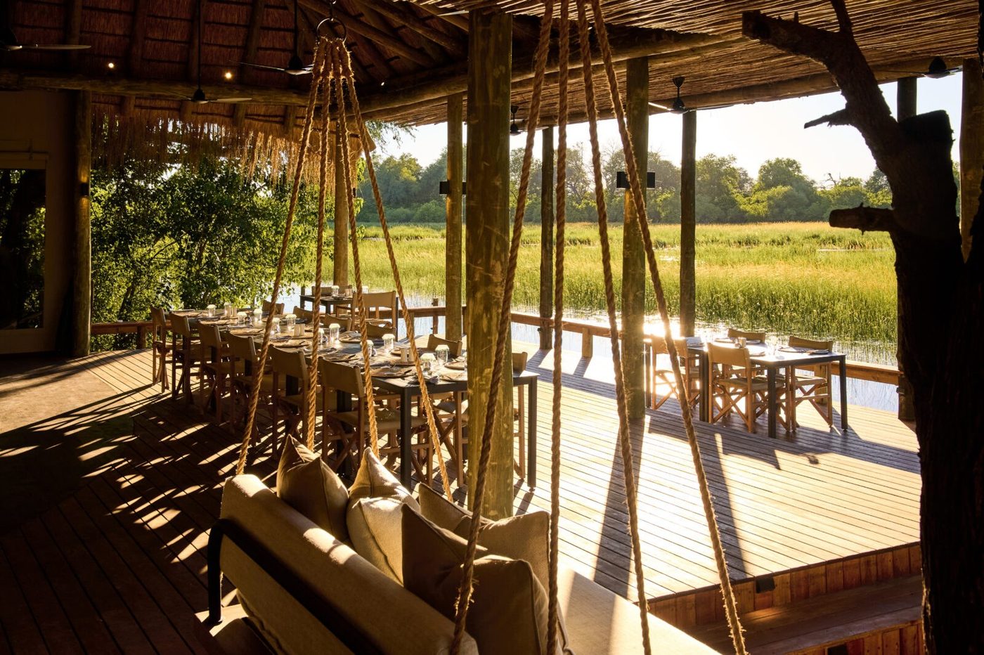 Dining deck under a rope-hung swing seat overlooking the reed bed at Sediba Sa Rona