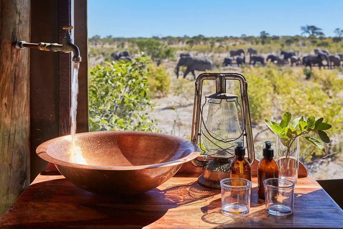 Copper basin and lantern in the Skybeds bathroom, elephants passing outside