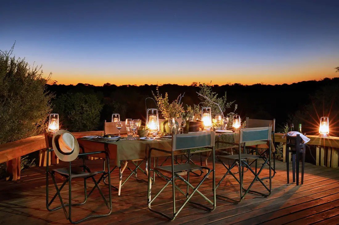 Lanterns light the dinner table on the shared Skybeds dining deck after sunset