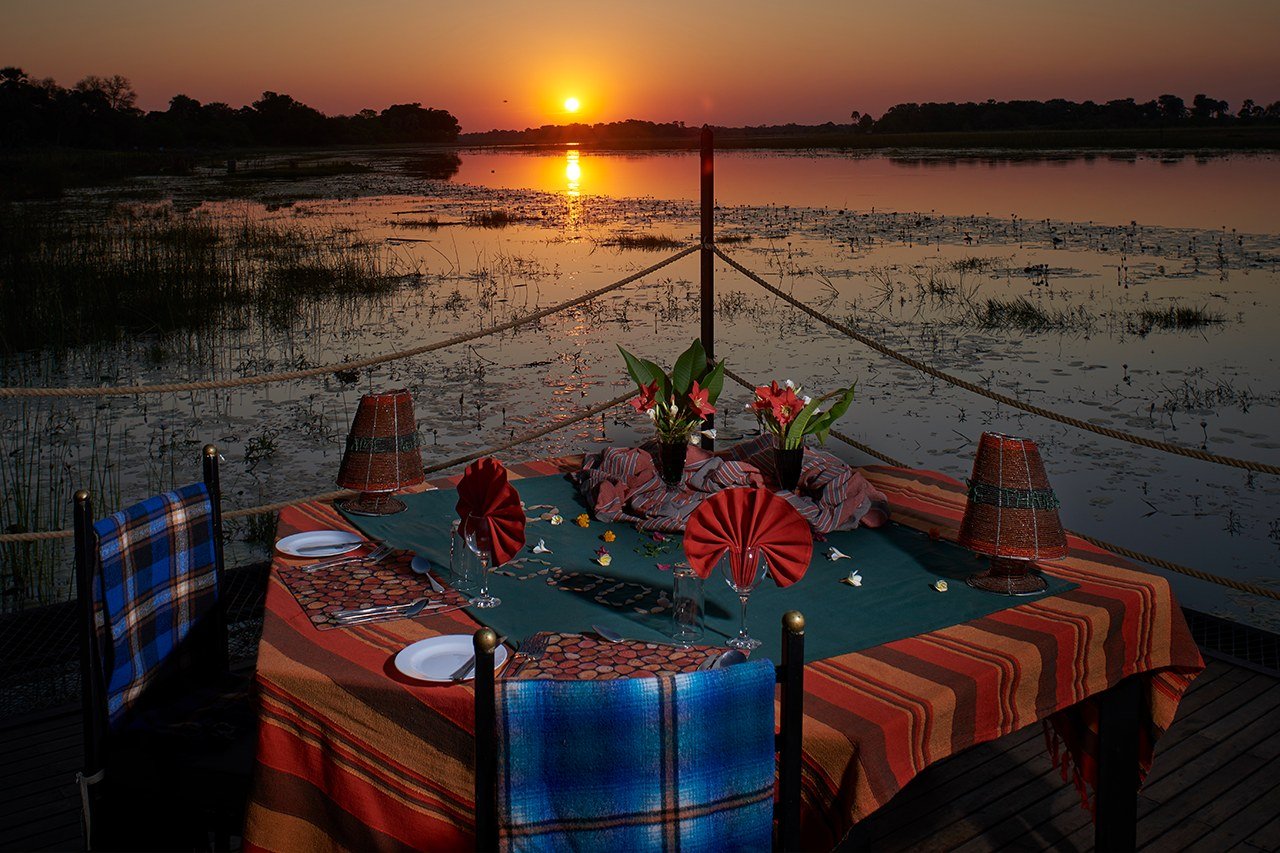 A sunset table laid on the floodplain deck at Thamalakane River Lodge