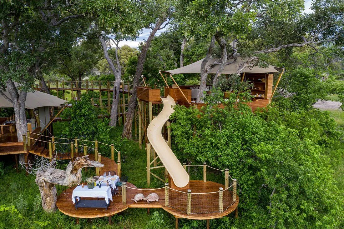 The raised treehouse library at Tuludi, with a slide curving down to a dining deck