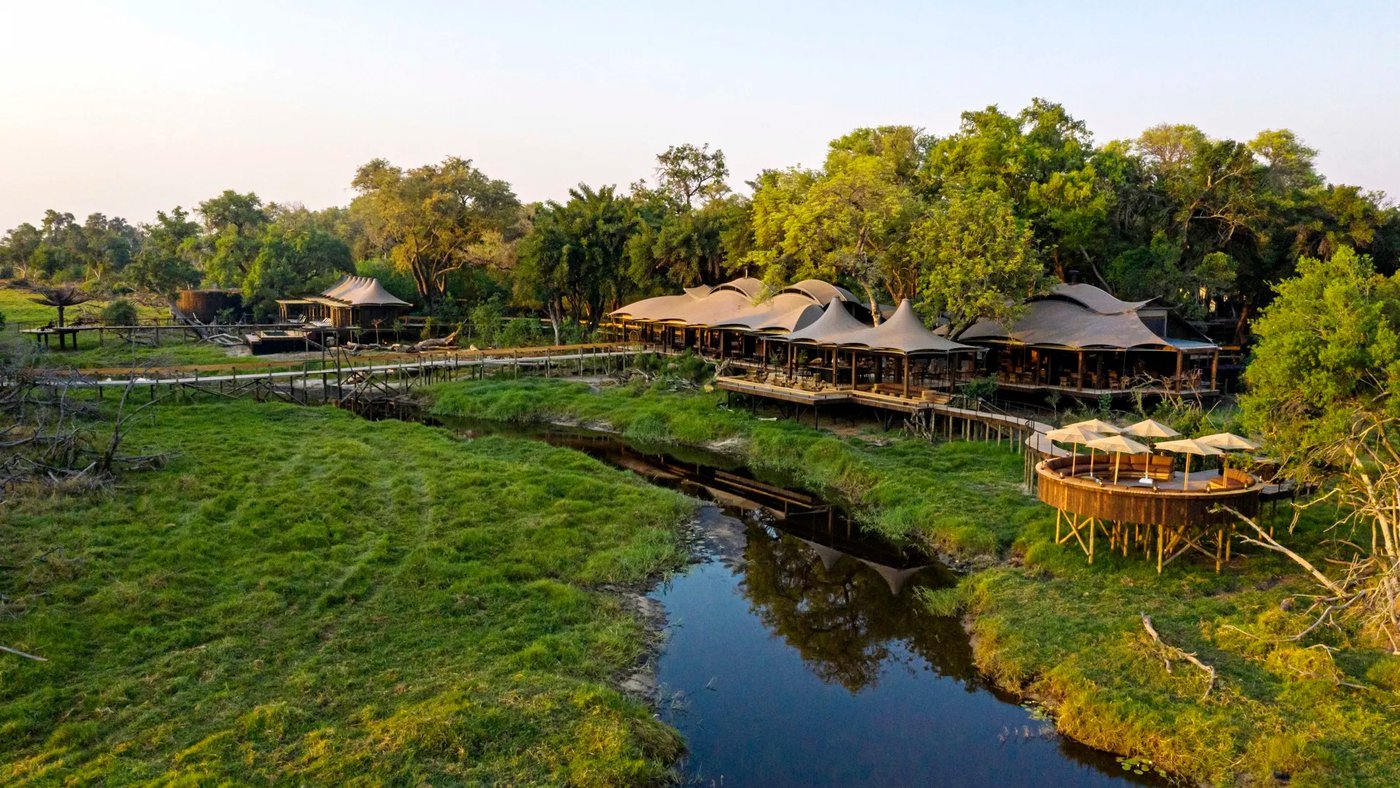 Thatched suites and a lotus-shaped deck beside a channel at Xigera Safari Lodge, Moremi